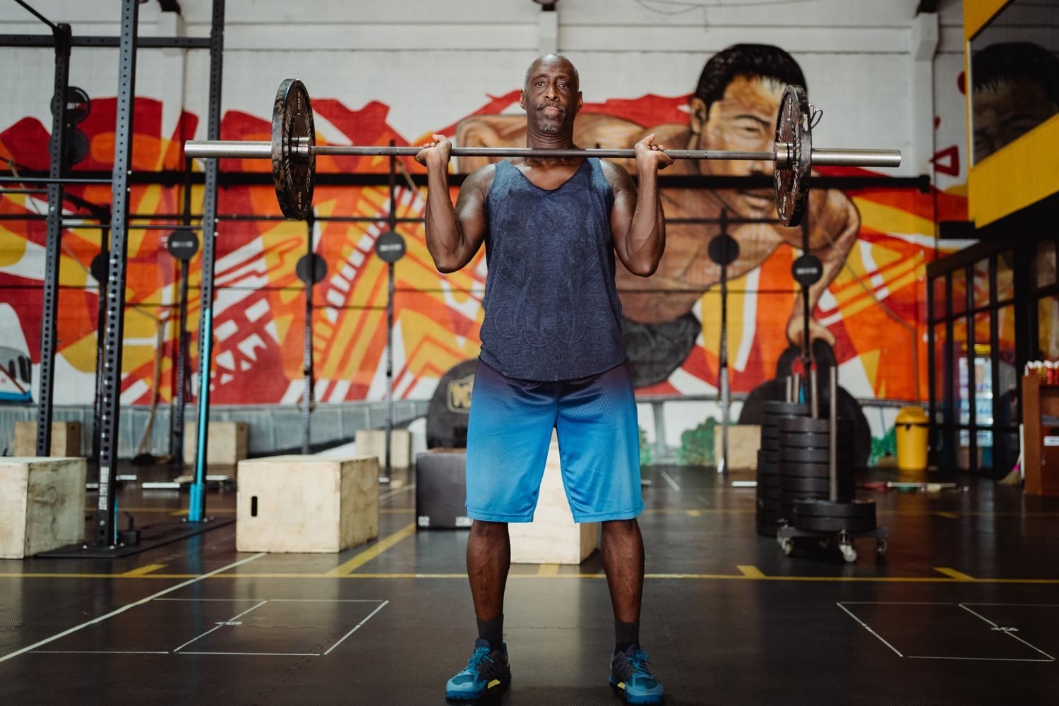 Man lifting a barbell overhead during a structured gym training session