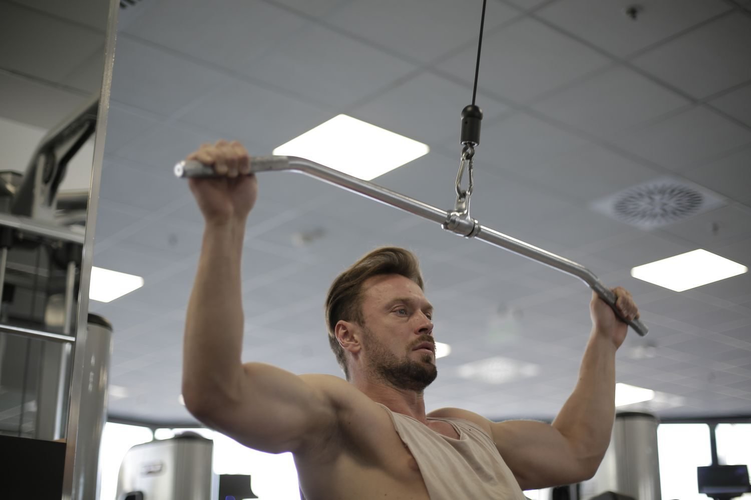 Man using a cable machine during a gym session as part of a full week workout plan