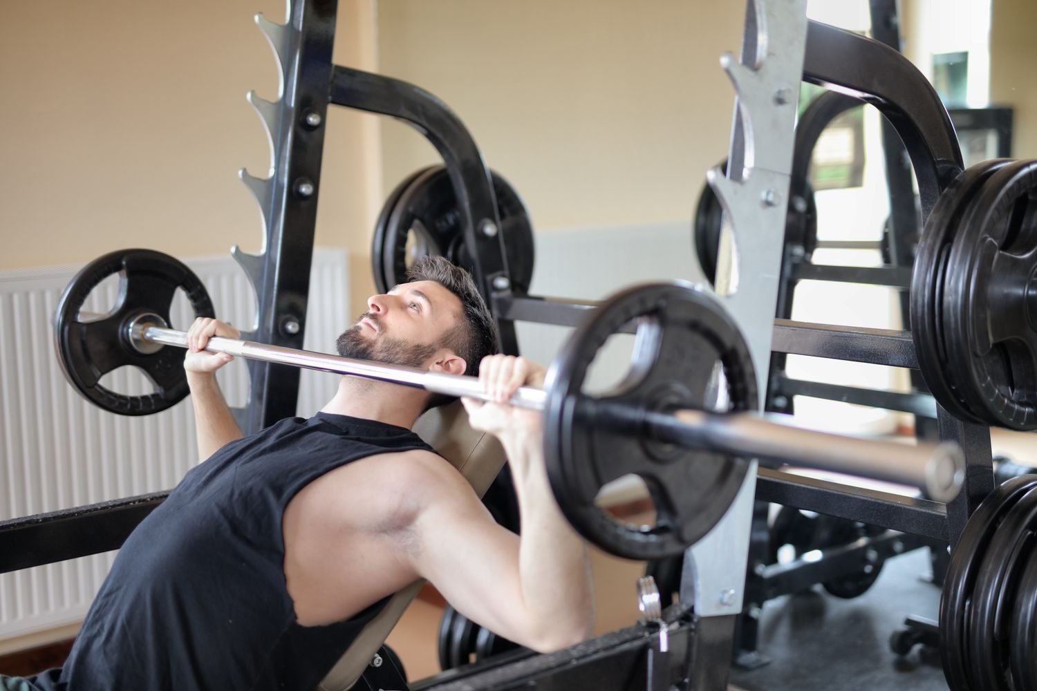 Man performing a bench press as part of a full week workout plan