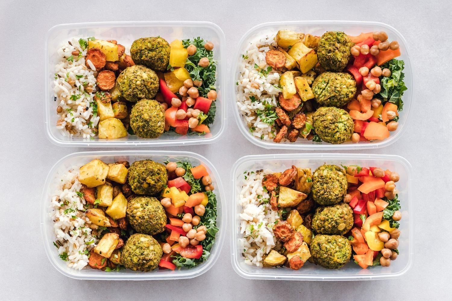 A week's worth of fatty liver diet meal prep containers with vegetables, whole grains, and legumes on a kitchen counter