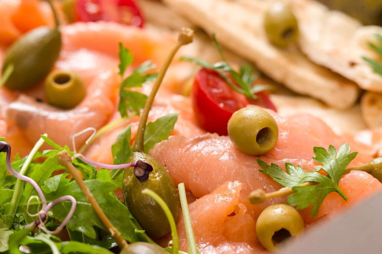Fresh anti-inflammatory foods including salmon, berries, leafy greens, olive oil, and walnuts arranged on a wooden table