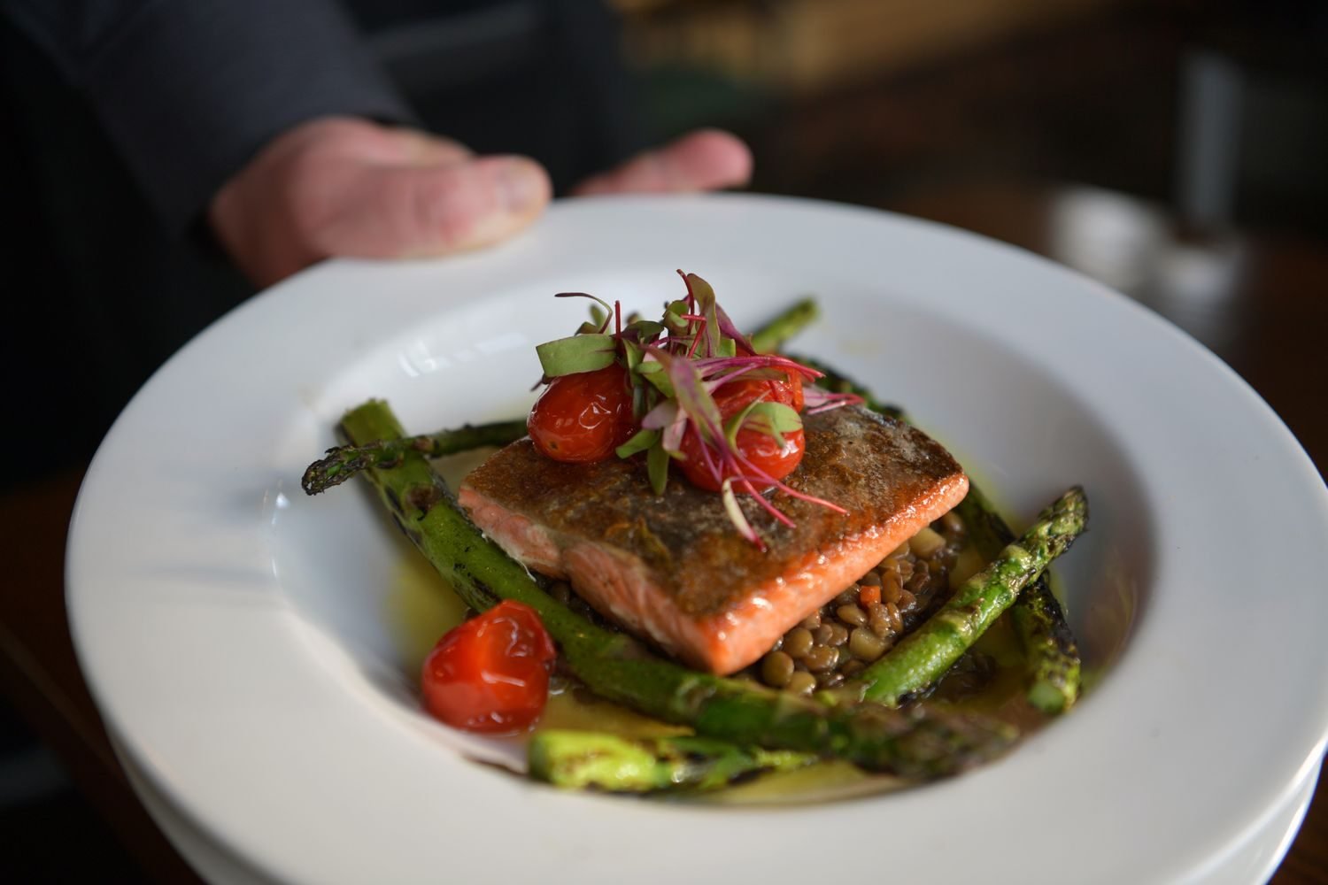 A balanced anti-inflammatory dinner plate with salmon, roasted vegetables, and a lentil dish drizzled with olive oil