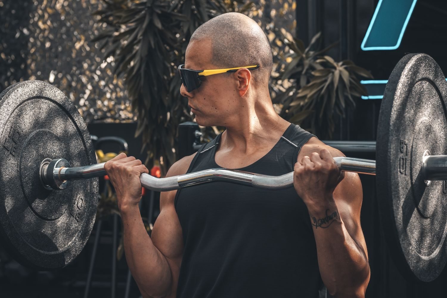 Man performing an EZ-bar bicep curl in the gym
