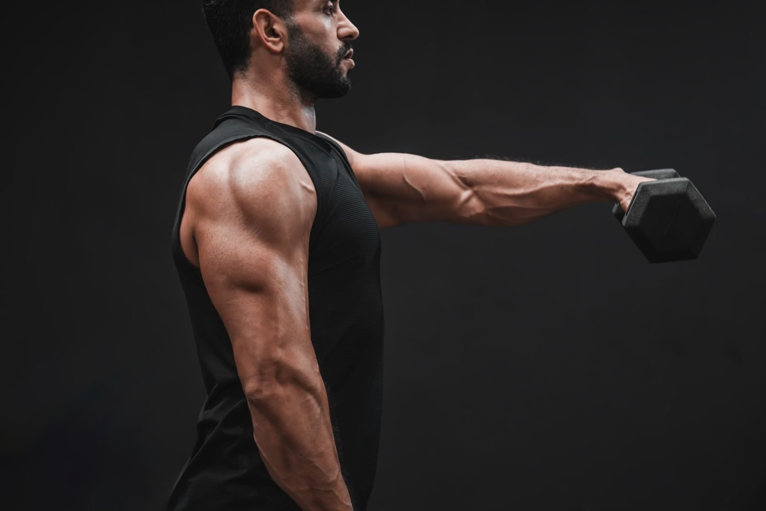 Man performing a dumbbell side lateral raise for shoulders