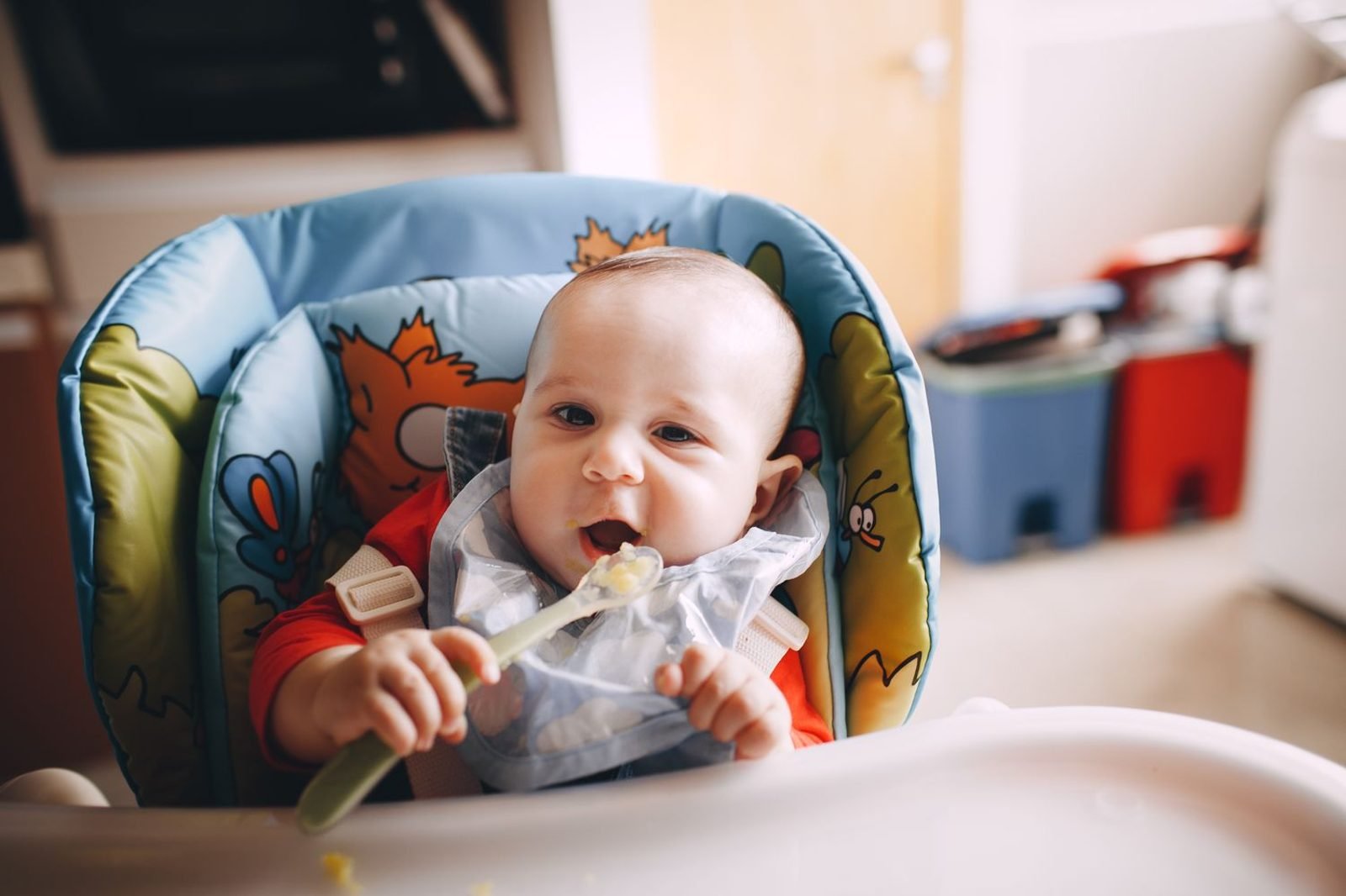 Baby in a high chair exploring solid foods, illustrating normal picky eating during weaning