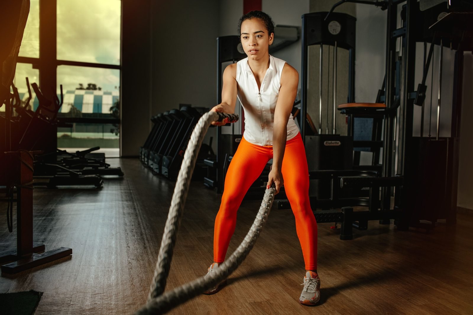 Woman performing battle rope slams in the gym