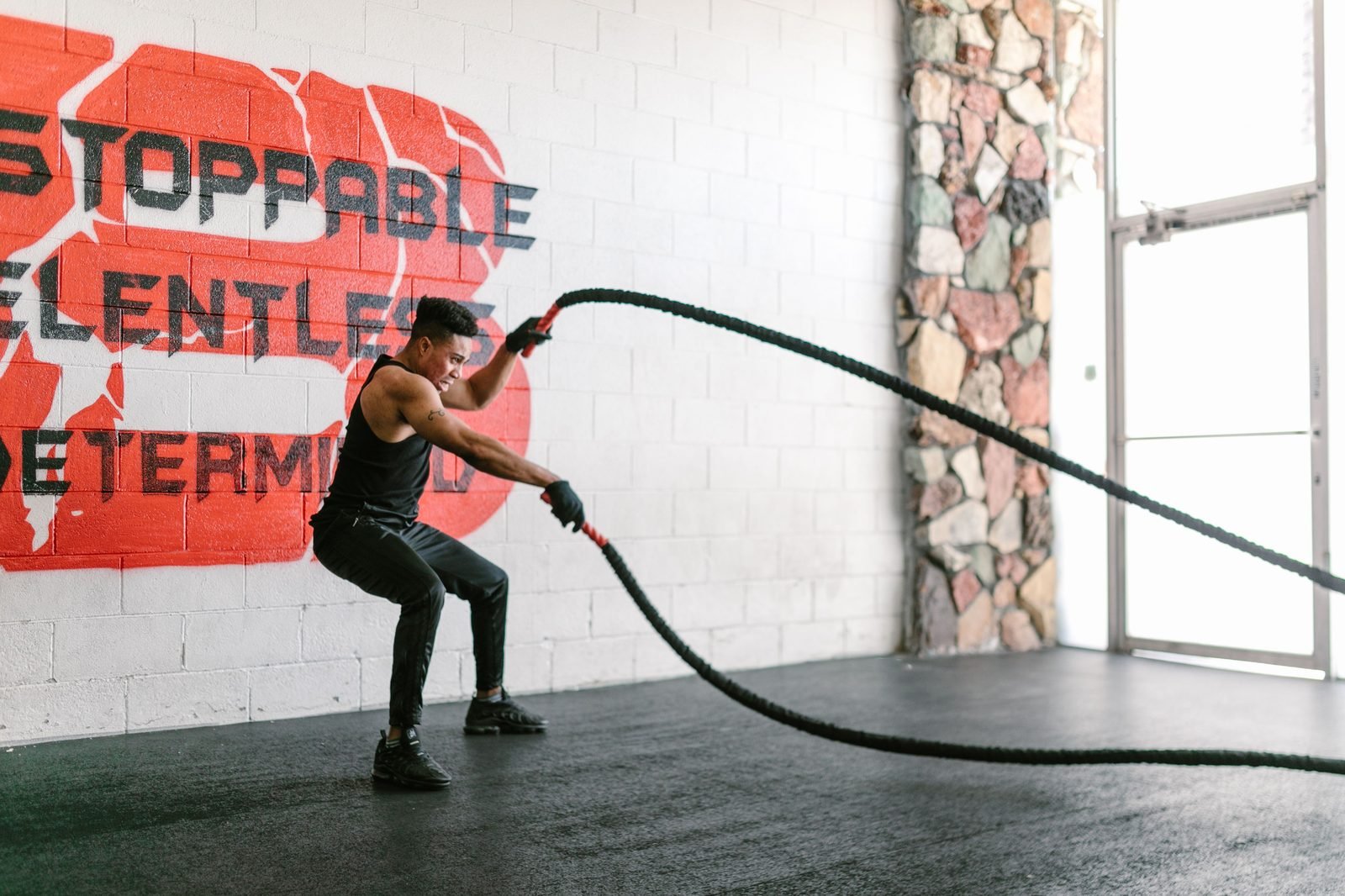Man performing battle rope waves in the gym