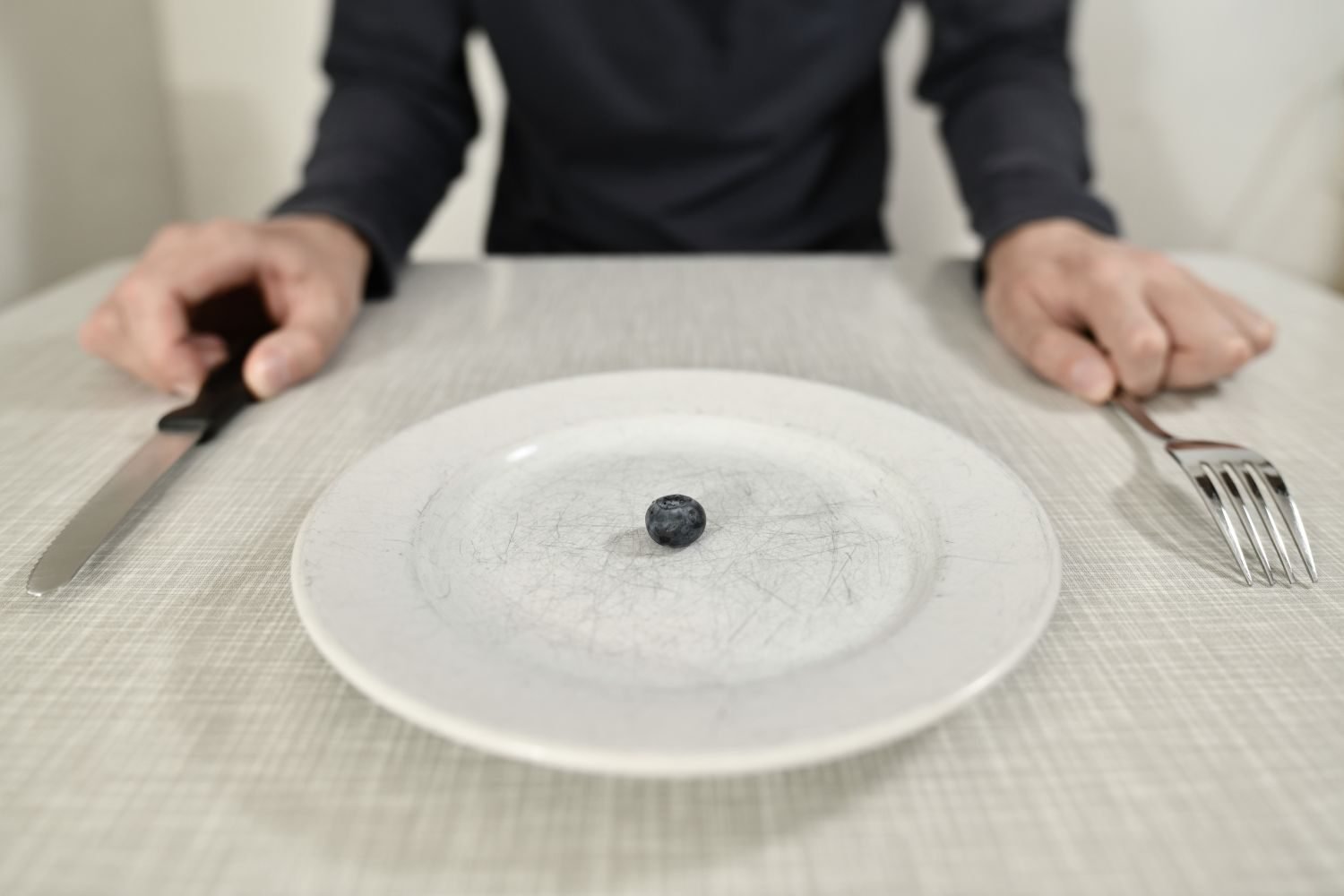 Clock and empty plate symbolizing a time-restricted eating window and open questions about long-term effects
