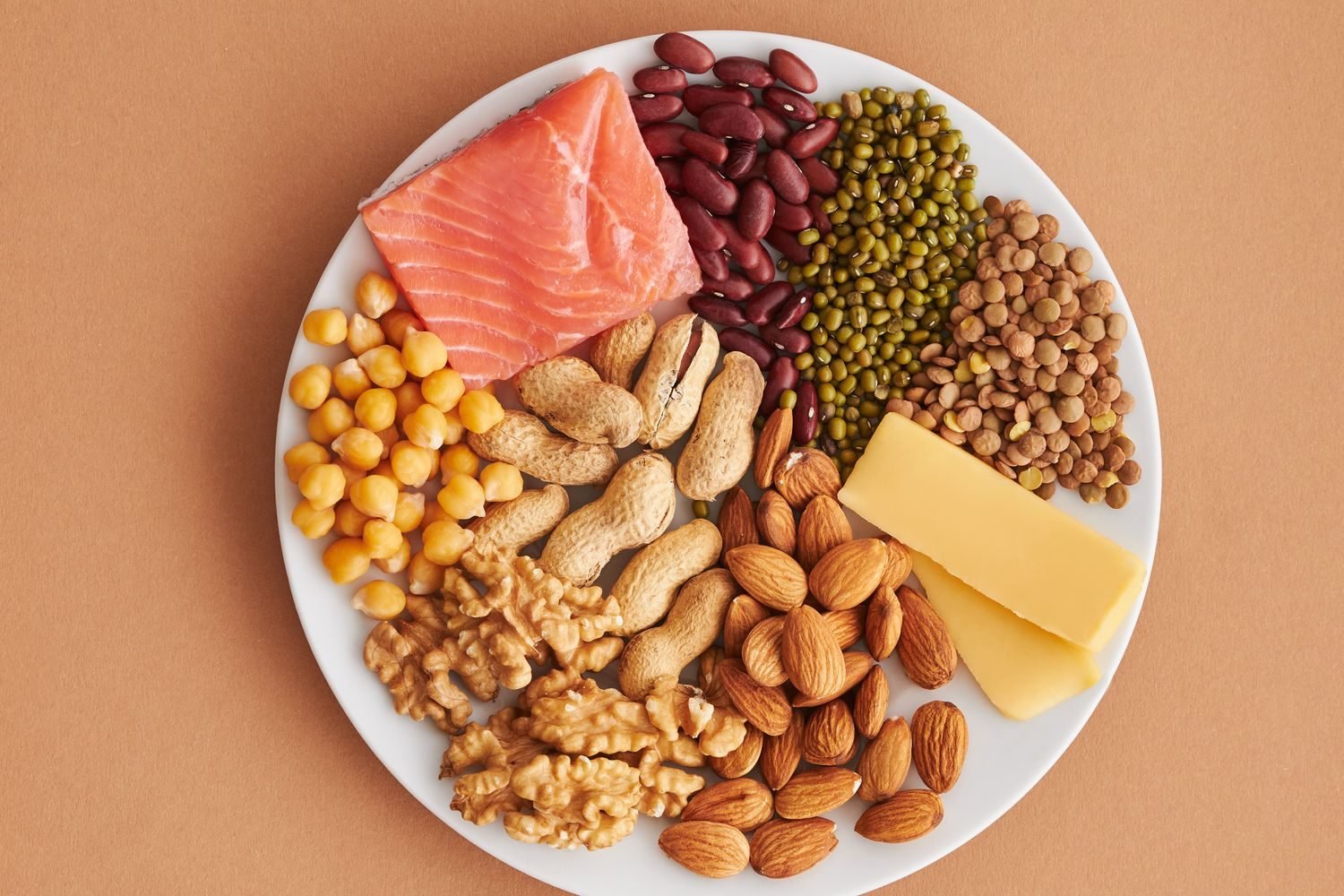Balanced plate of menopause-friendly foods including leafy greens, salmon, beans, and dairy for calcium and protein