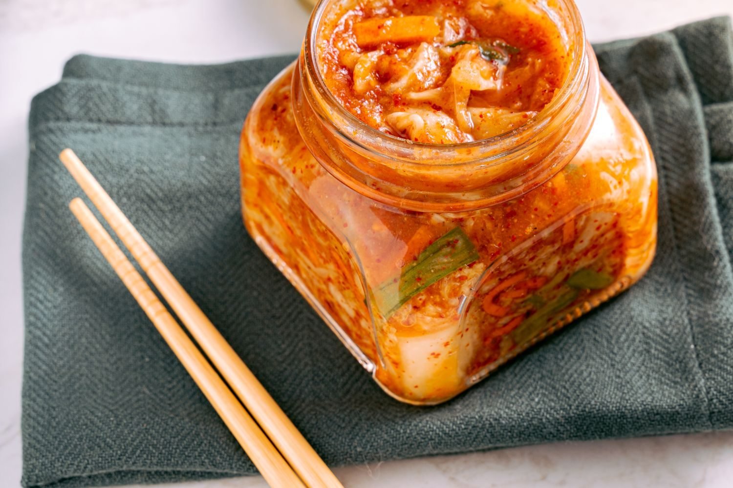 Bowl of yogurt with berries alongside kimchi and sauerkraut, fermented foods linked to gut-brain axis research