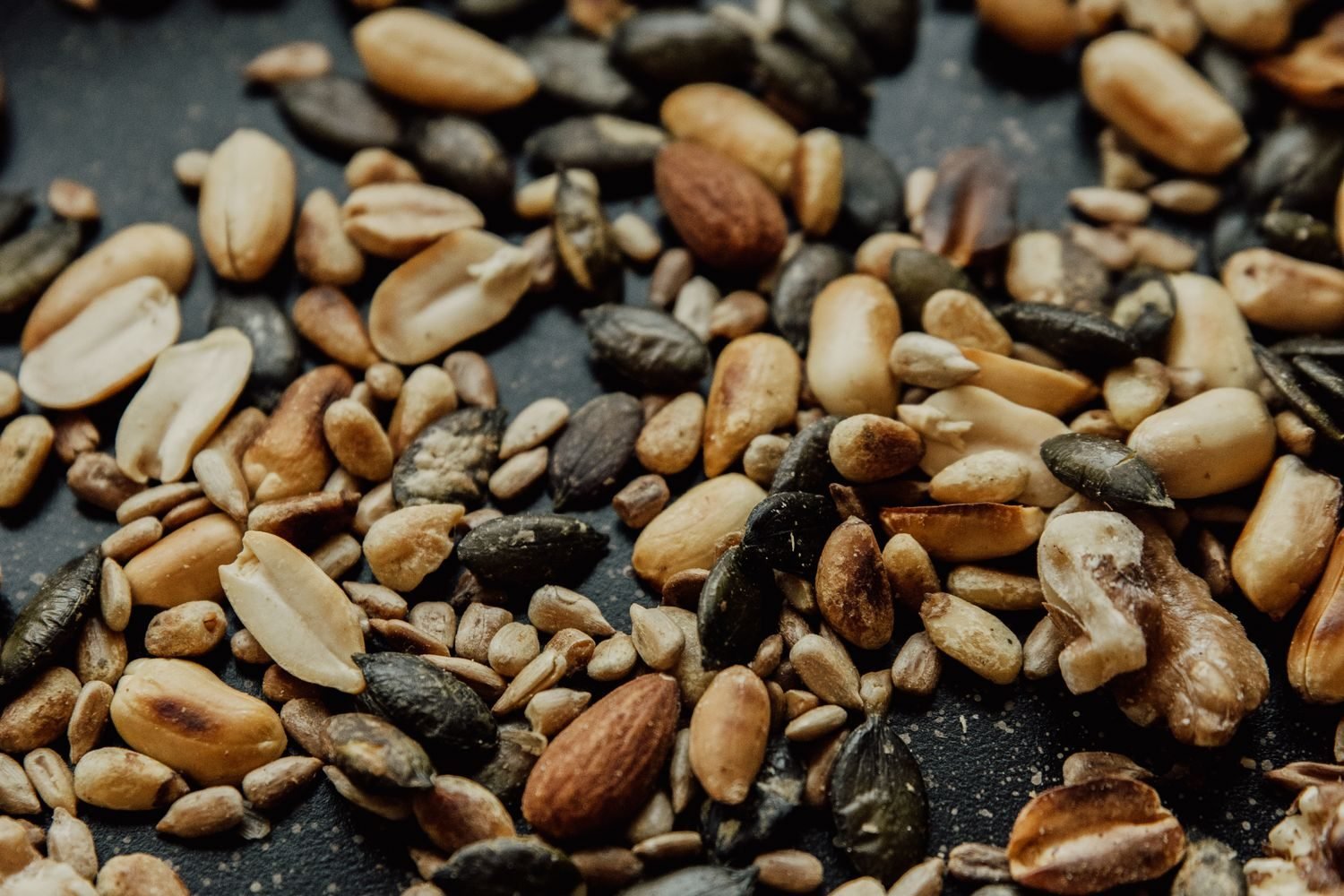 Foods rich in magnesium including almonds, spinach, and pumpkin seeds arranged on a wooden table