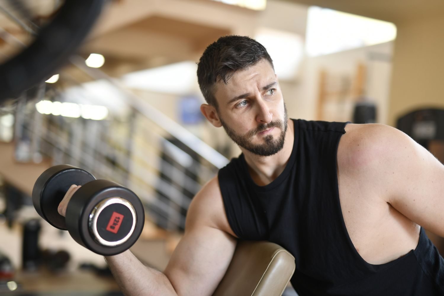 Man performing a dumbbell bicep curl in a gym