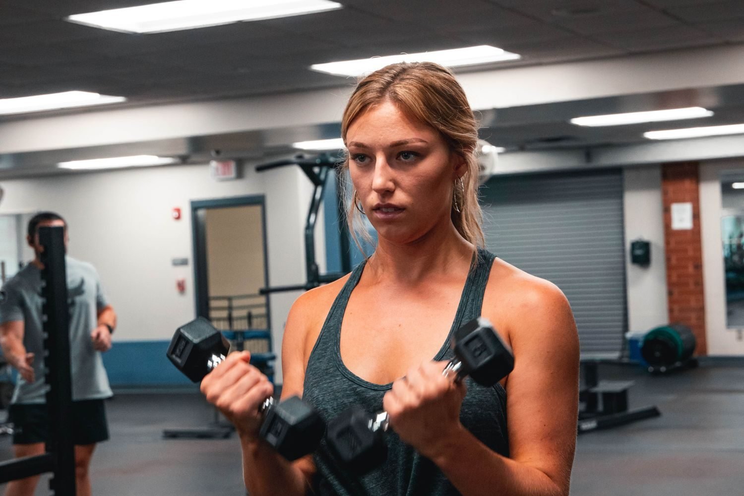 Woman performing a dumbbell bicep curl in the gym
