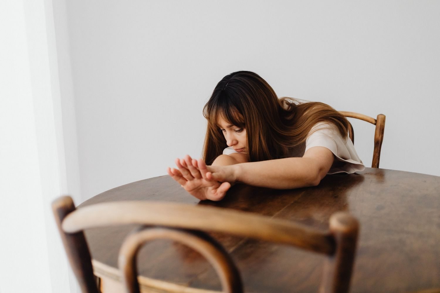 Person sitting alone looking distressed near an empty plate, representing emotional distress after a binge eating episode