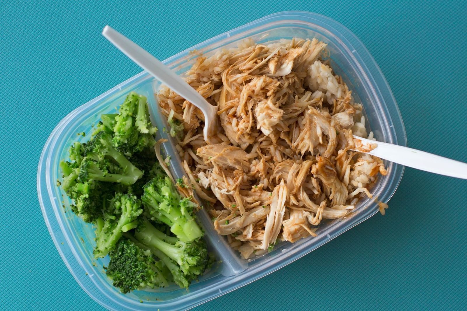 Bodybuilder meal prepping high-protein meals with chicken, rice, and vegetables for a bulking phase