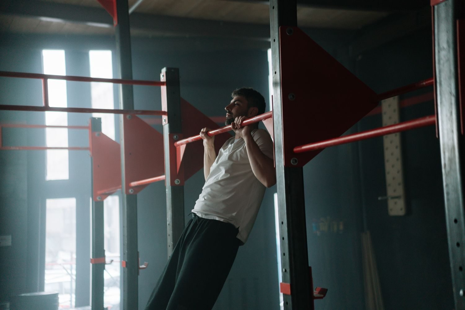 Man performing a pull-up on an outdoor pull-up bar