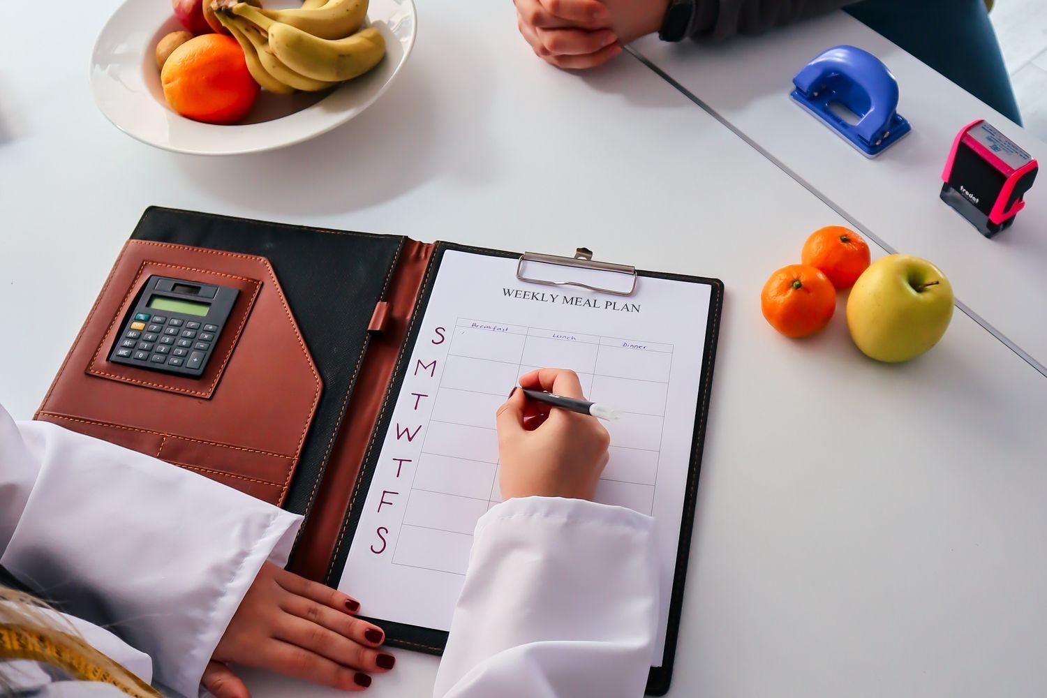 Nutritionist reviewing a client's body composition and training log to set personalized muscle-building calorie targets