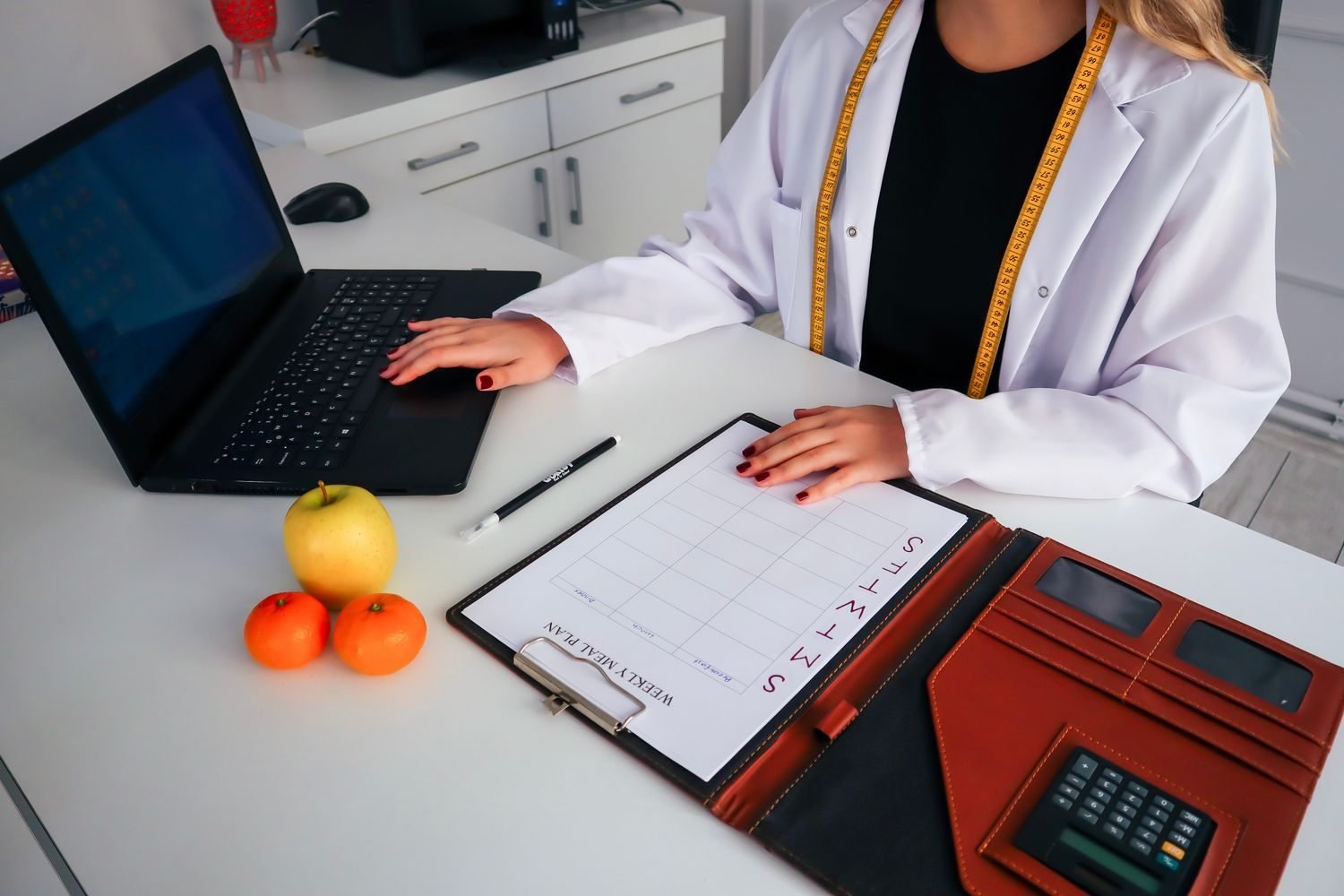 Nutritionist and client reviewing a periodized muscle-building meal plan alongside a training calendar