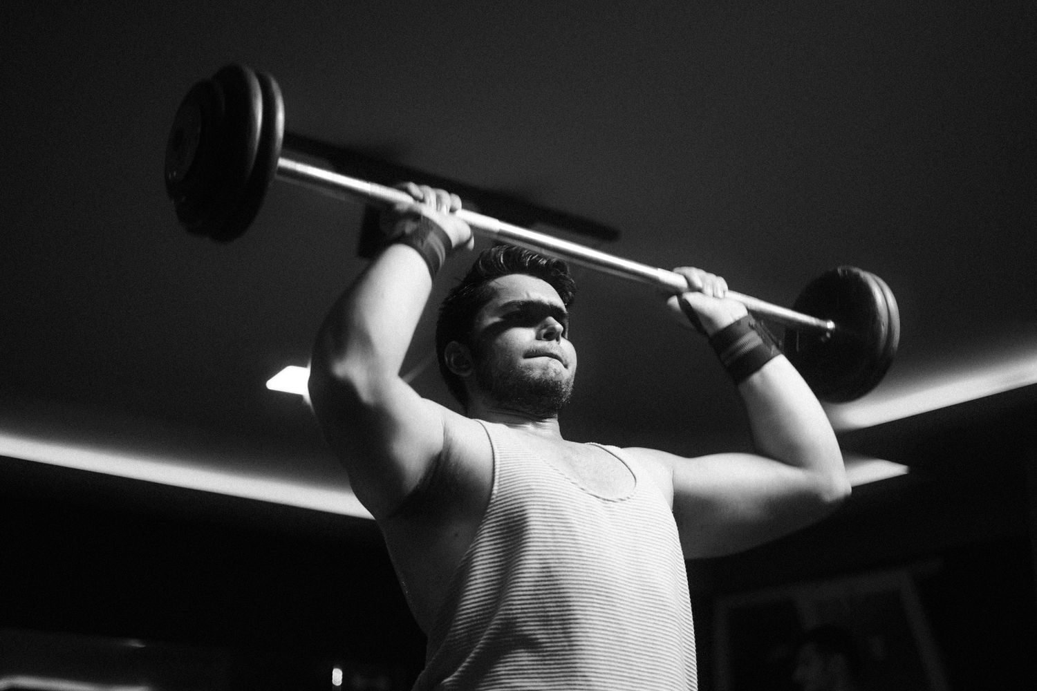 Man performing an overhead shoulder press during a push day workout