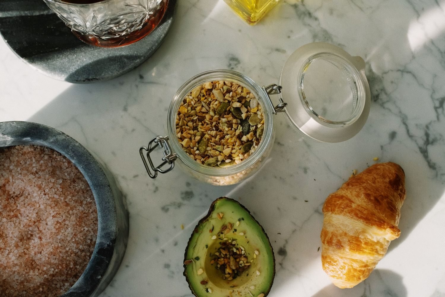 Assortment of cholesterol-lowering foods including walnuts, legumes, olive oil, and avocado on a table