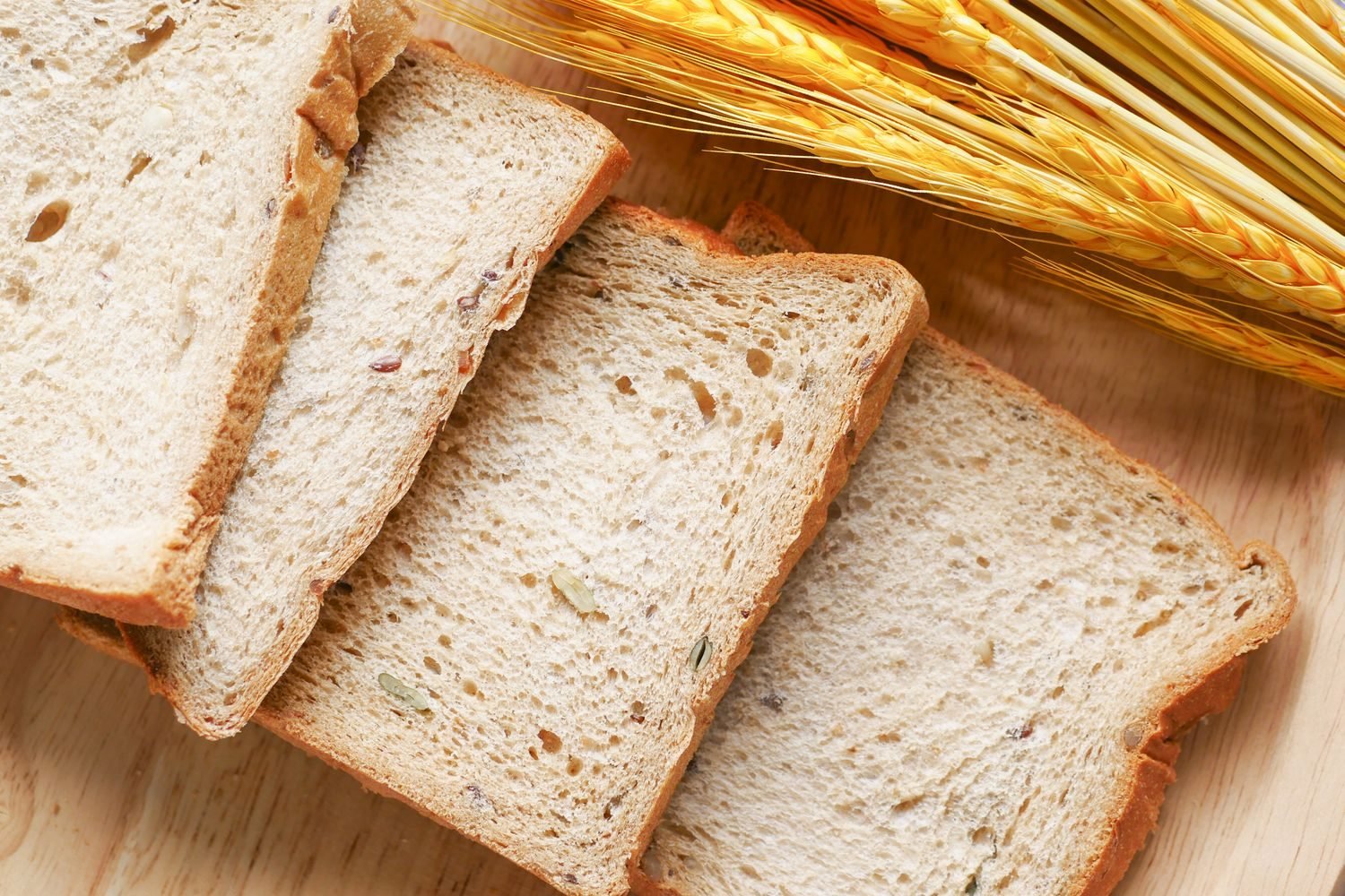 Close-up comparison of whole grain bread and white bread slices showing visible texture and fiber differences