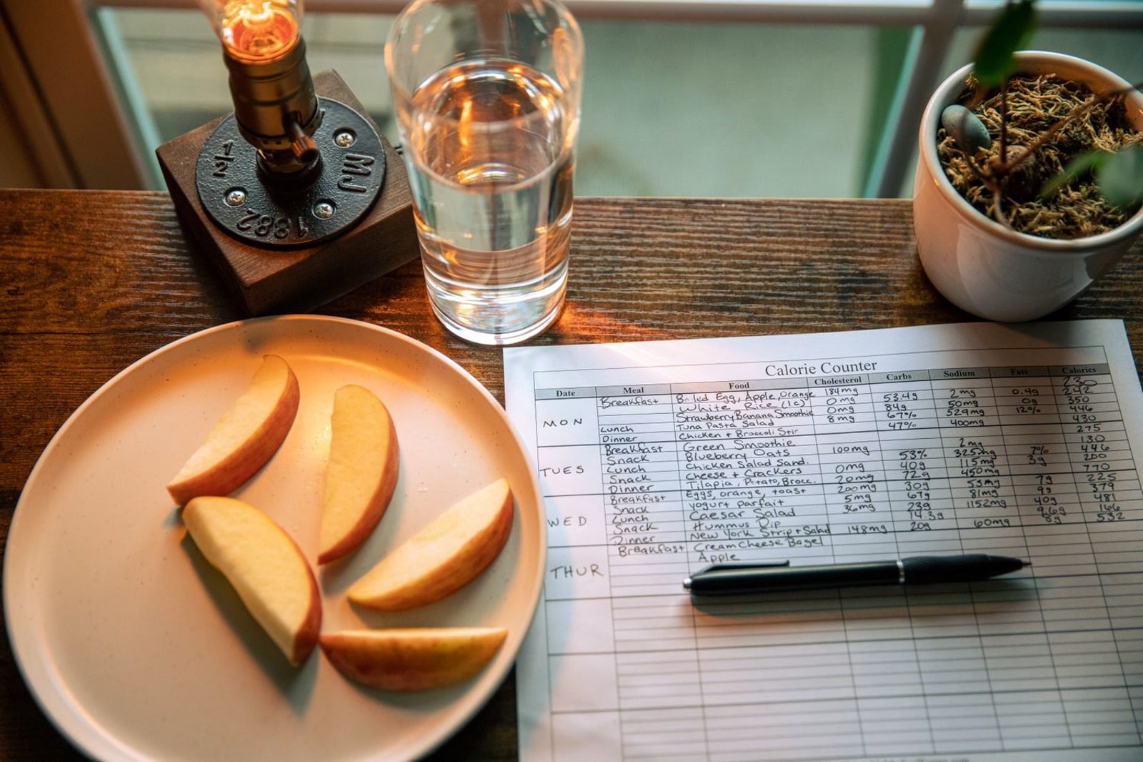 Man reviewing a daily nutrition and calorie reference chart on a tablet in a kitchen