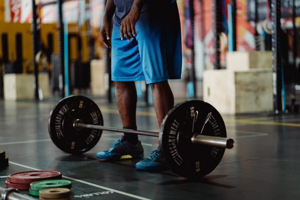 Man standing over a loaded barbell on the gym floor preparing his deadlift setup