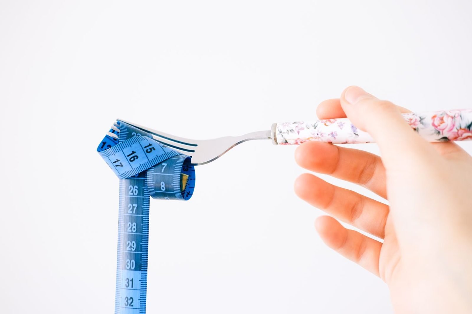 Hand measuring a portion of rice and vegetables to demonstrate basic carbohydrate counting for diabetes