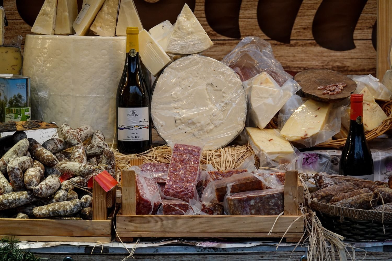 Assortment of common migraine trigger foods including aged cheese, red wine, processed meat, and chocolate arranged on a table