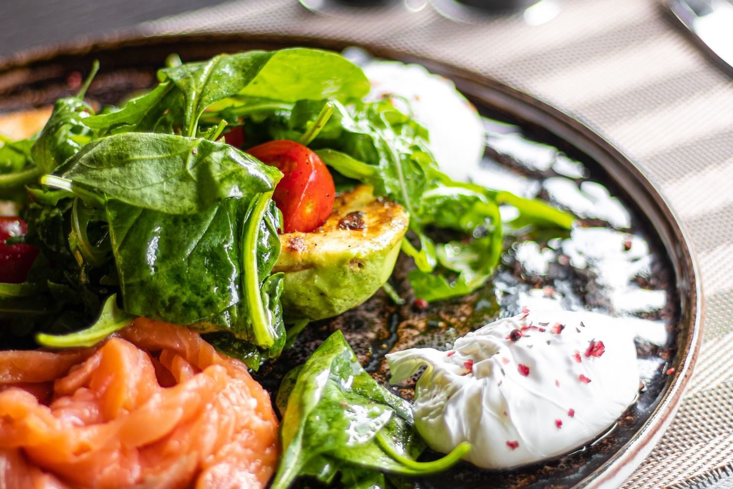 Nerve-supportive foods including salmon, leafy greens, walnuts, and eggs arranged on a table