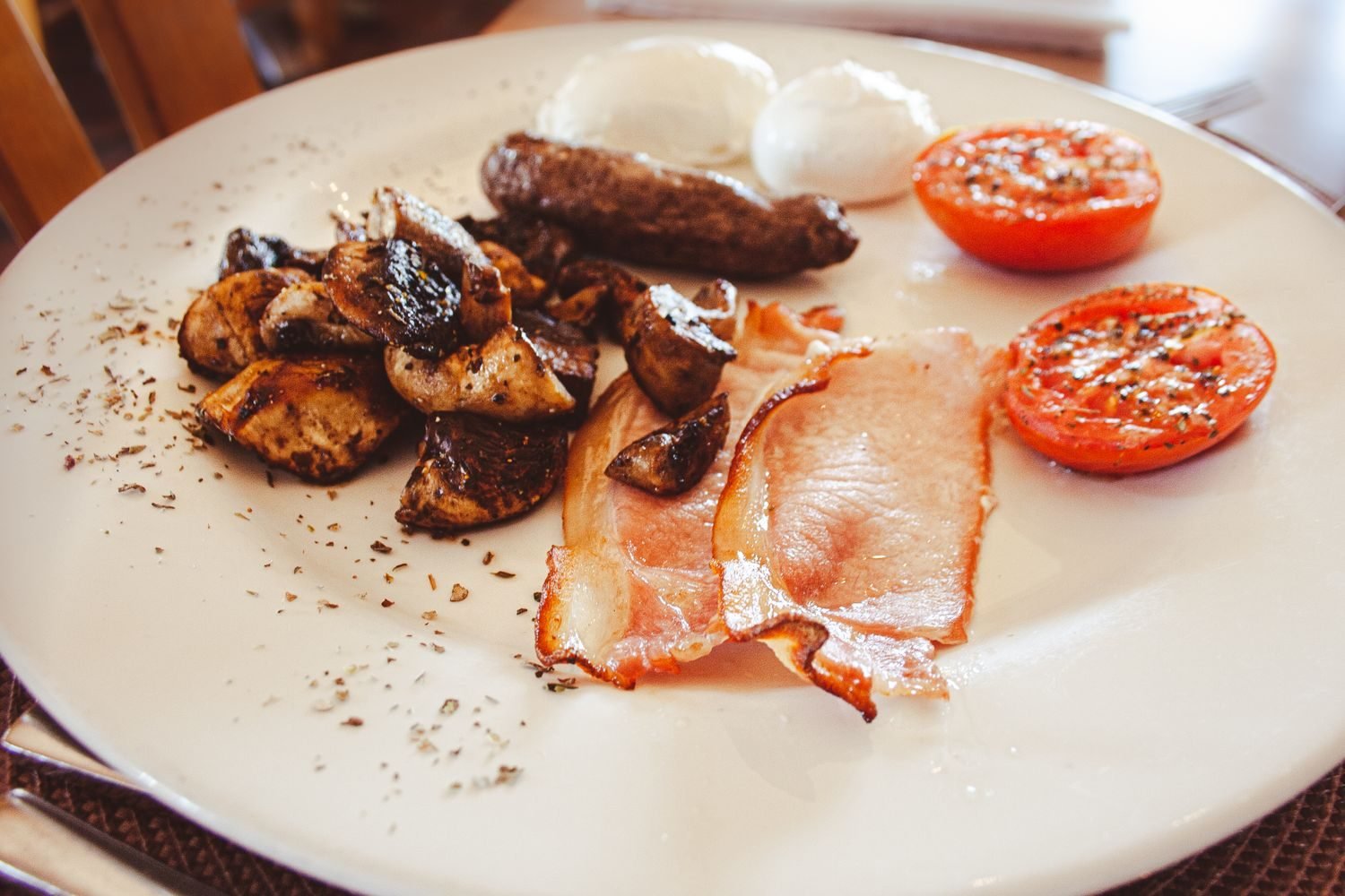 Eggs next to bacon and sausage illustrating the dietary cholesterol versus saturated fat distinction