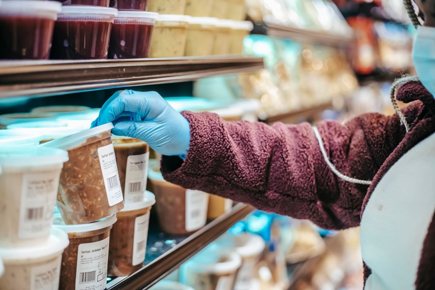 Hand reading the ingredient list on the back of a packaged food label to spot hidden sugar