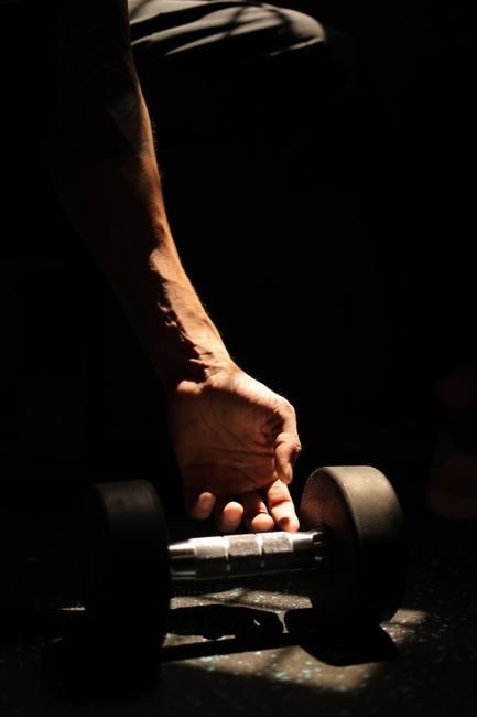 Close-up of a hand gripping a dumbbell, highlighting forearm and grip engagement
