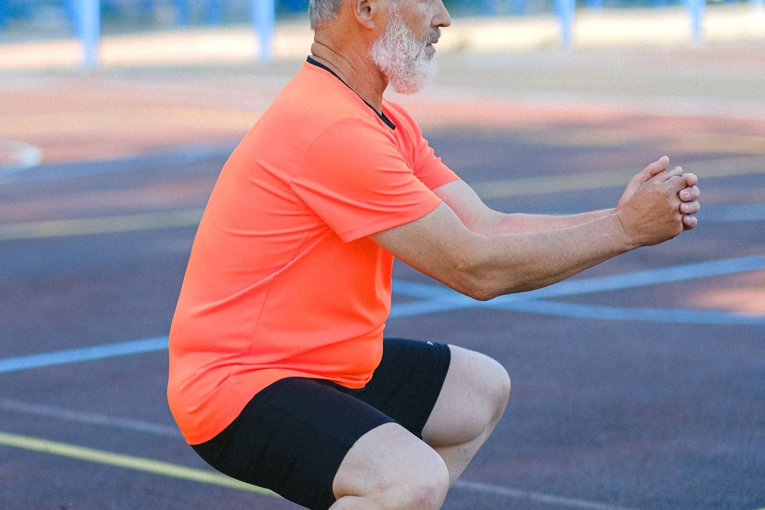 Man performing a bodyweight squat as part of a full body workout