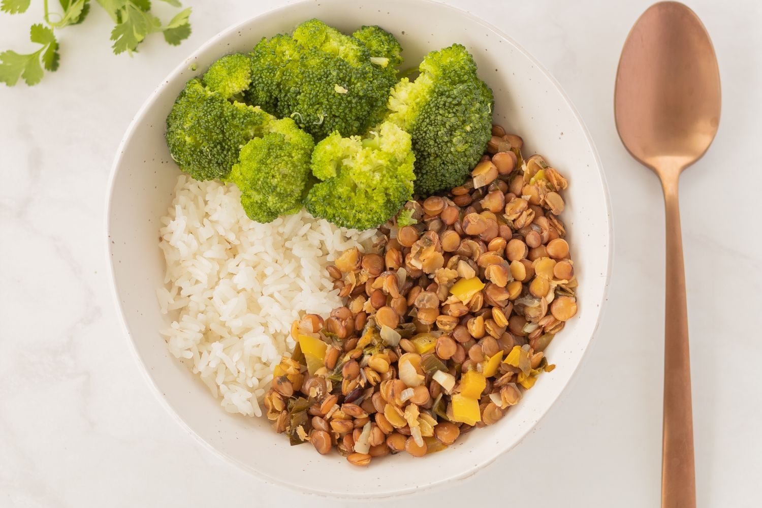 Plate of naturally gluten-free whole foods including rice, lentils, vegetables, and quinoa