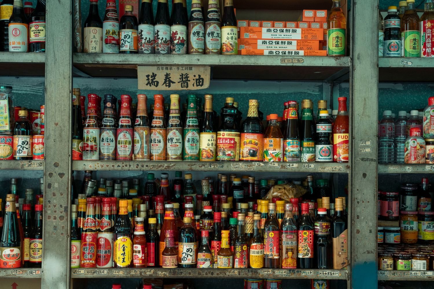Hing asafoetida spice tin next to soy sauce bottle, highlighting hidden gluten sources in Indian cooking