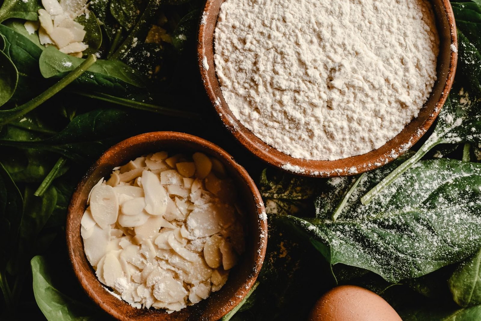 Flat lay of Indian hair-healthy foods including eggs, spinach, lentils, almonds, and pumpkin seeds arranged on a wooden table