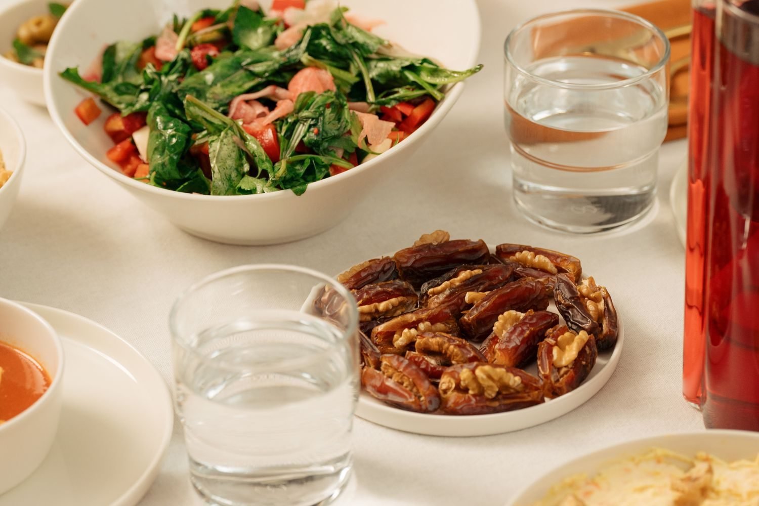 Iftar table with dates, water, and soup arranged for gradually breaking a Ramadan fast