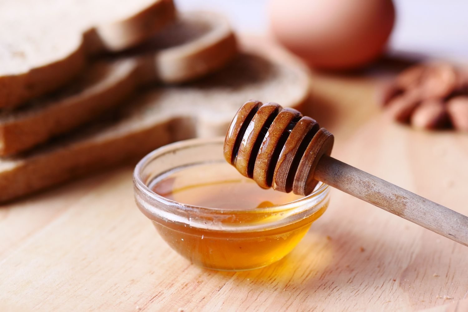 Assorted natural sweeteners including honey, jaggery, dates, and maple syrup arranged on a wooden table