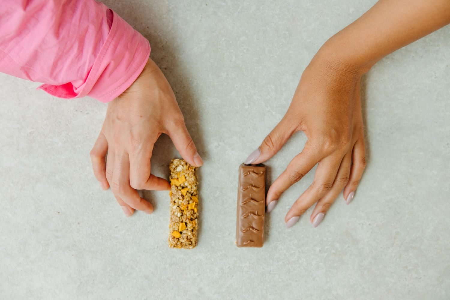Hand comparing sodium content on nutrition labels of packaged foods