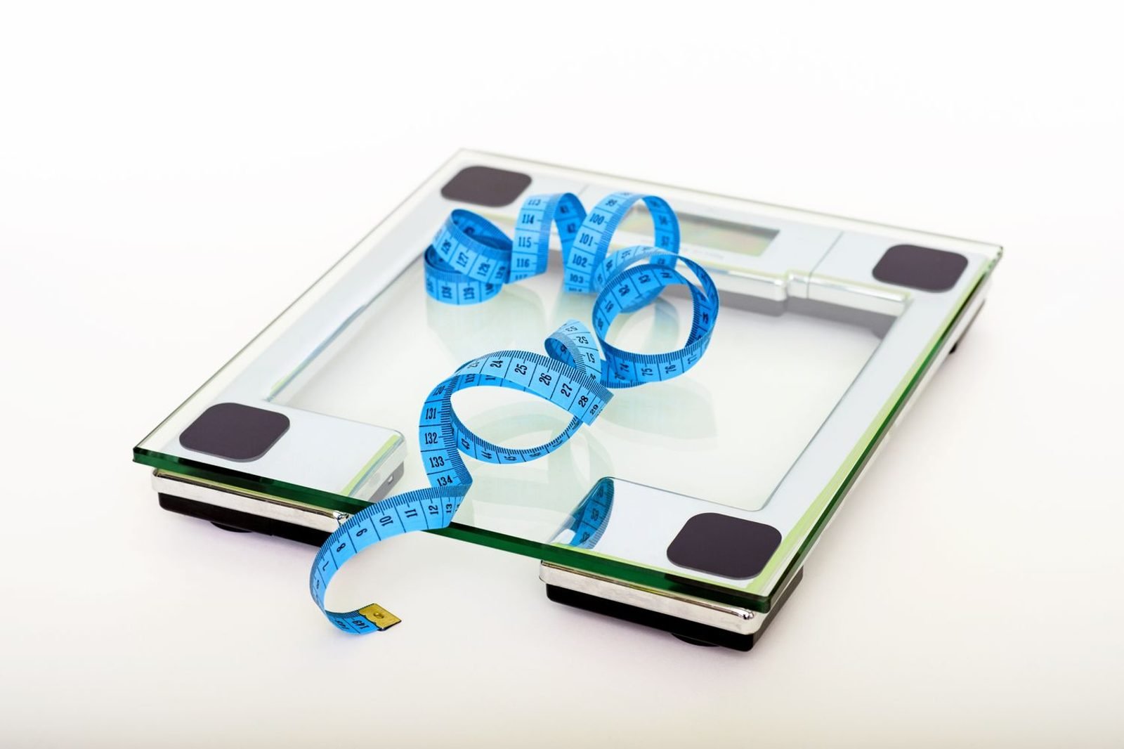 Green tea leaves and a cup of brewed green tea next to a measuring tape, representing evidence-based herbal nutrition for weight loss