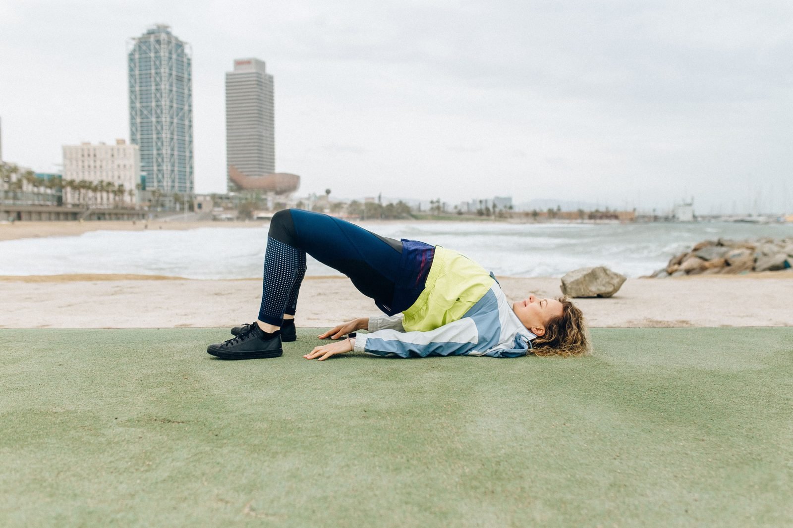Woman performing a glute bridge exercise outdoors