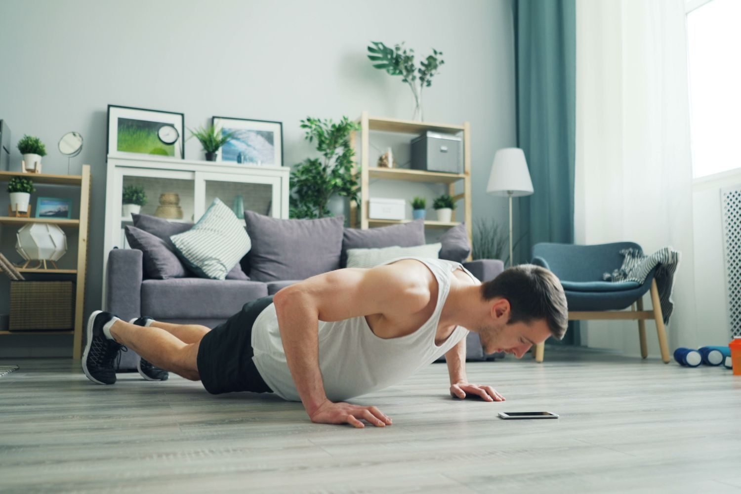 Man doing a push-up during a bodyweight home workout in his living room