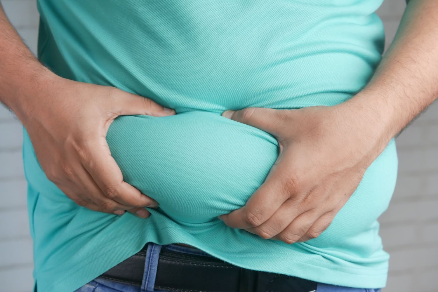 Diagram showing how chronic cortisol elevation from stress contributes to visceral fat storage around the abdomen