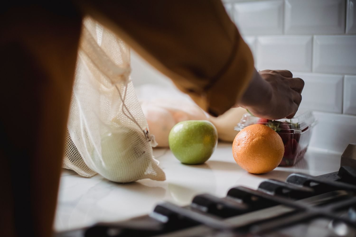 Person prepping simple batch meals in a kitchen as a strategy for managing stress-related convenience food reliance