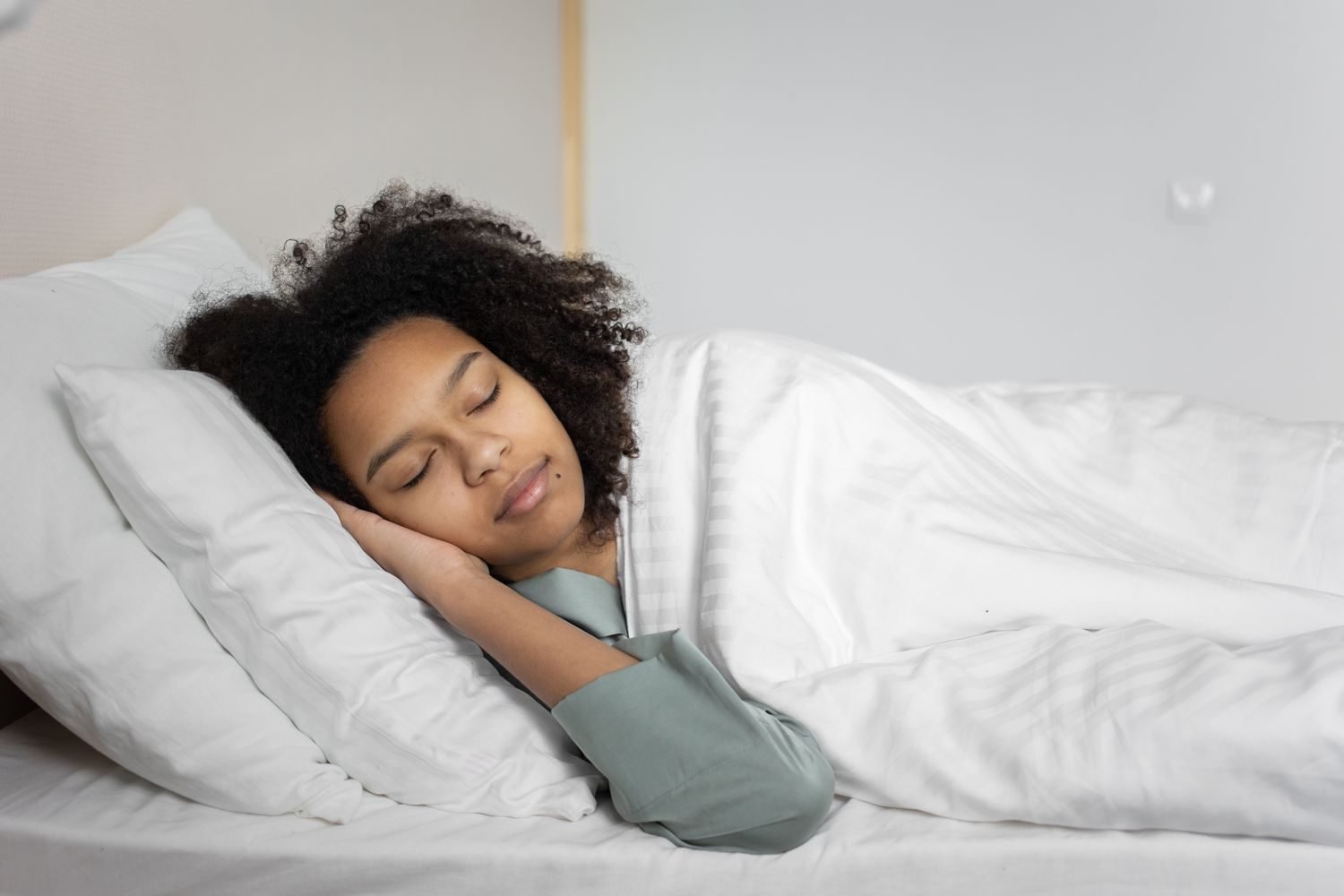 Person sleeping peacefully in bed, representing the link between sleep quality and reduced sugar cravings