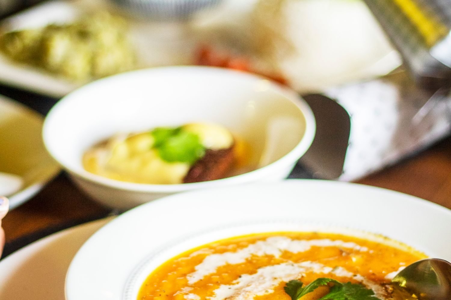 Person portioning vegetables, dal, and roti onto a plate following the healthy plate method