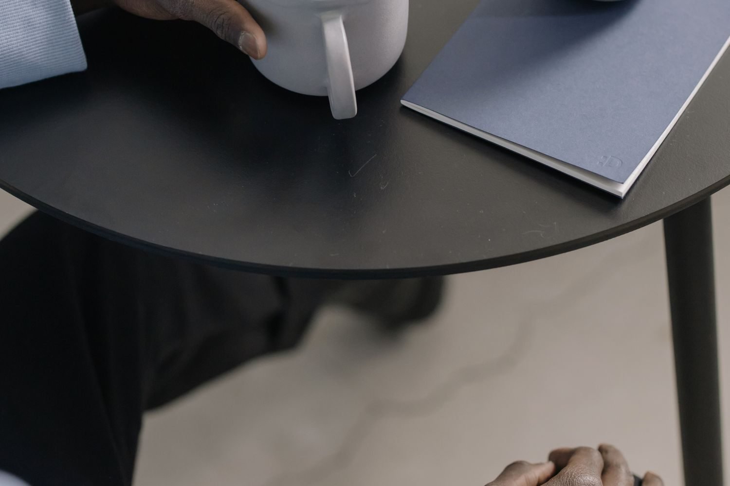 Close-up of hands holding a warm cup, representing a calm, self-compassionate pause rather than self-criticism