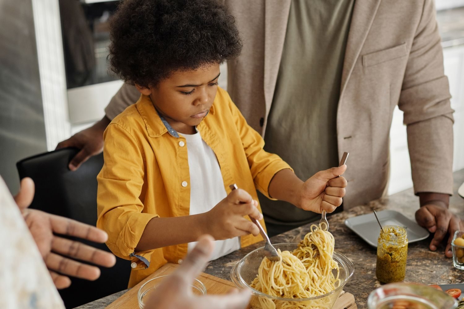 Family cooking a low-sodium heart-healthy dinner together at home after a heart disease diagnosis