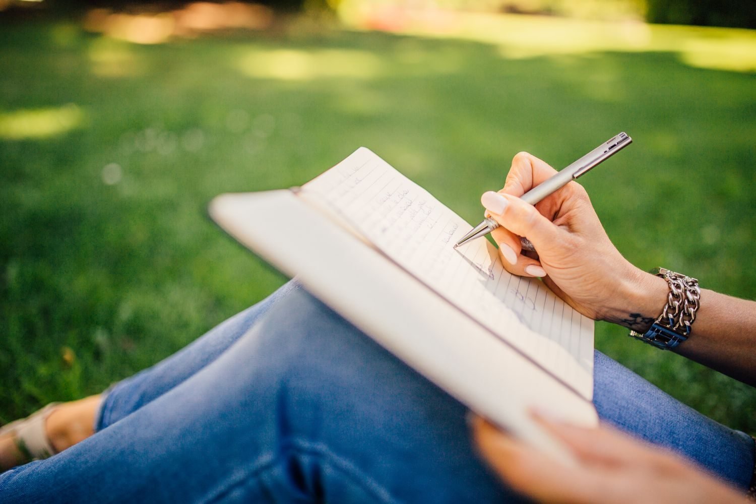 Person journaling and taking a mindful pause outdoors instead of reaching for food during a stressful moment